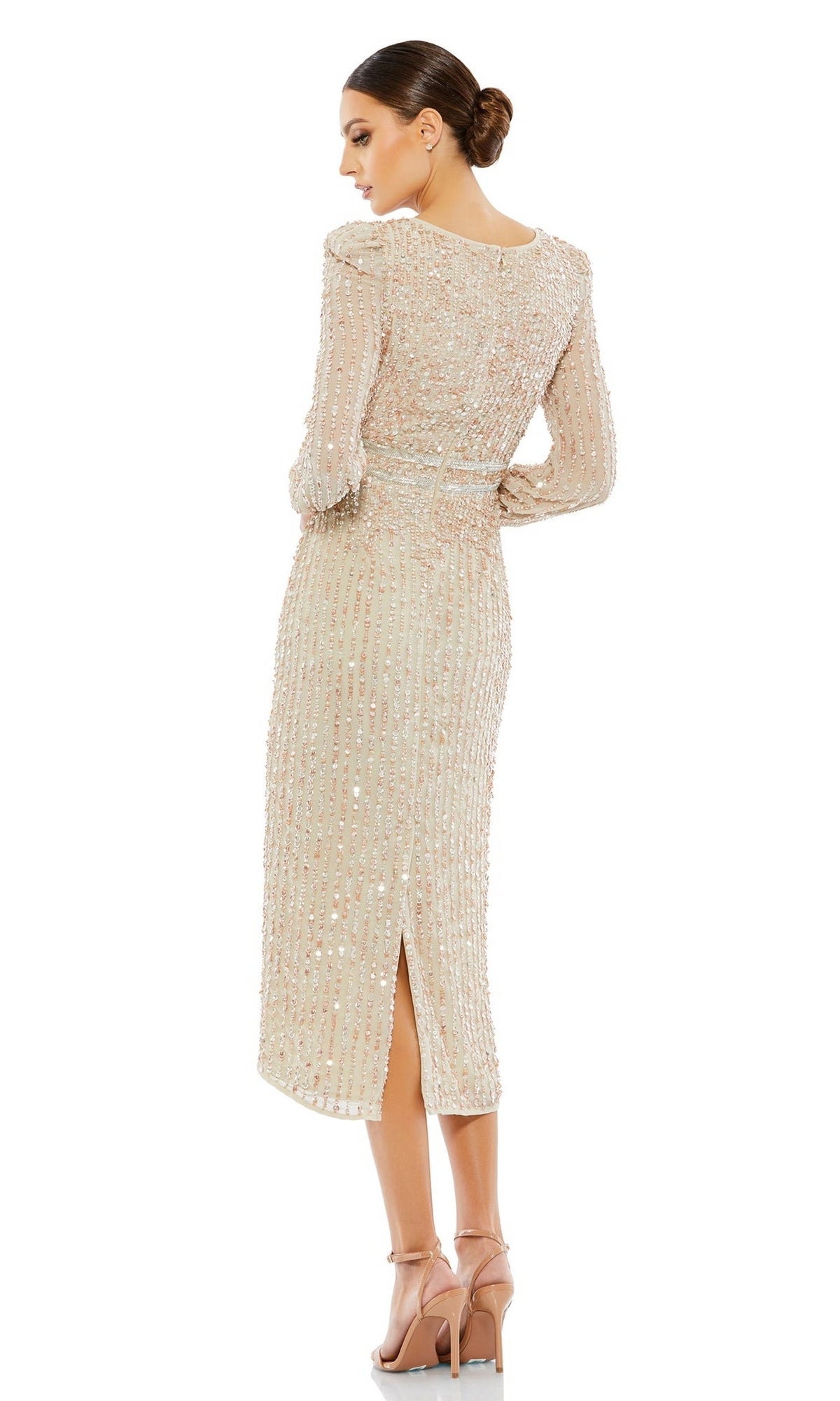 Woman wears the Mac Duggal 93593 Knee-Length Wedding Guest Dress in beige, featuring long sleeves and beaded embellishments; she stands sideways with her back visible, hair in a sleek bun, paired with high heels.